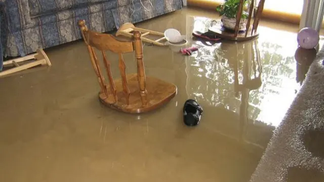 Water-stained floorboards and subfloor showing damage under hardwood