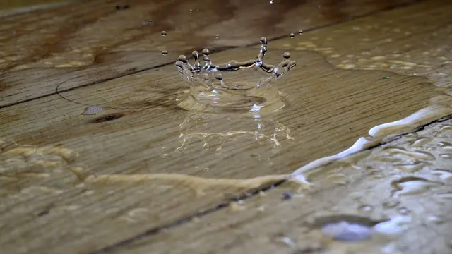 Water pooling on a hardwood floor after a leak